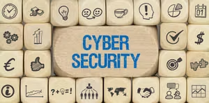 Holzbausteine mit dem Schriftzug Cyber Security und Symbolen für digitale Sicherheit
