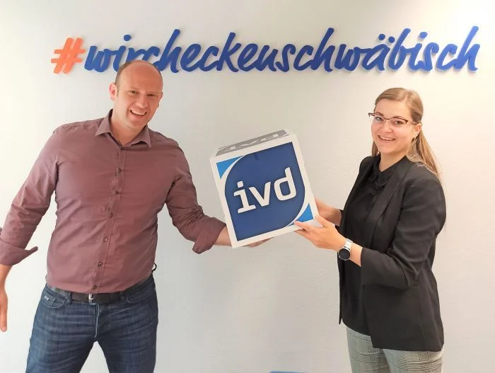 Slobodan Starcevic und Janine Mößner mit dem Zeichen des Immobilienverbands Deutschland IVD