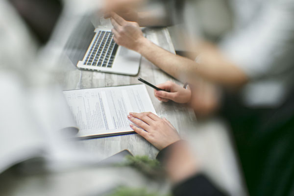 Beratungsgespräch mit Laptop und Unterlagen am Tisch