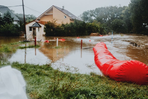 Überflutetes Grundstück mit Haus und Hochwasserschutz