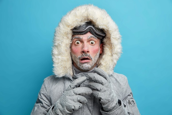 Mann in Winterkleidung mit überraschter Miene