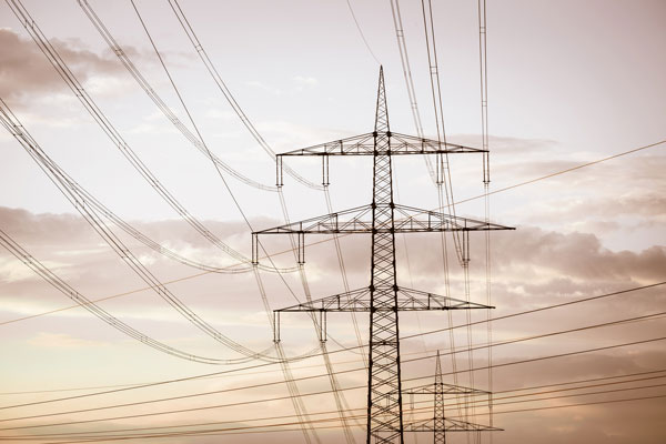 Strommast und Hochspannungsleitungen im Gegenlicht