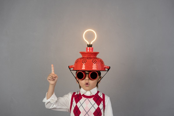 Person mit Schutzhelm und leuchtender Glühbirne als Symbol für Modernisierungsideen
