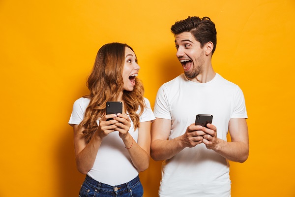 Paar mit Smartphones reagiert überrascht